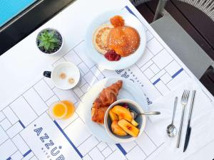 a table with a plate of breakfast food and a bowl of fruit at Novotel Monte-Carlo in Monte Carlo