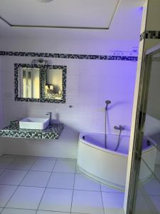 a white bathroom with a tub and a sink at Willa Euforia in Poznań