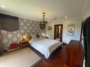 1 dormitorio con cama y lámpara de araña en Comfortable Luxury Home en Perth