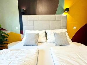 1 Schlafzimmer mit 2 Betten mit weißer Bettwäsche und Kissen in der Unterkunft Kreative Wohnung mit Balkon in Wien