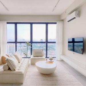 - un salon avec un canapé blanc et une grande fenêtre dans l'établissement HomeCinema with Seaview, 8pax, Urban Suites by PG Home, à George Town