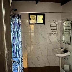a bathroom with a shower curtain and a sink at LO de Yamaha in Rocha
