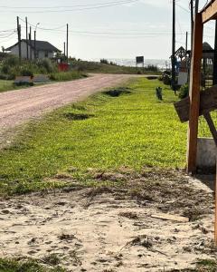 un camino de tierra junto a un campo de césped verde en LO de Yamaha, en Rocha