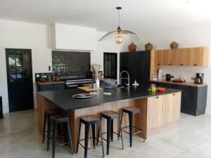 a kitchen with a large island with bar stools at Mas du Cuirassier- Vacances en Provence! in Châteaurenard