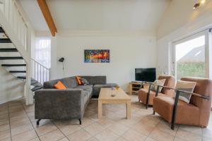 ein Wohnzimmer mit Sofa, Sesseln und Fernseher in der Unterkunft Vakantiehuis Duyngroet - Landal park Ooghduyne Julianadorp aan Zee in Julianadorp + 29 Fotos