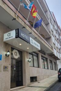 a hotel with flags flying in front of it at Hotel Alda Boiro in Boiro