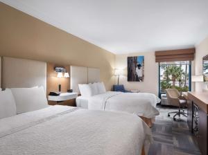 a hotel room with two beds and a desk at Hampton Inn Charleston North in Charleston