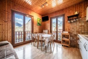 een keuken met een tafel en stoelen en bergen bij Au soleil des coeurs - 6 pers in Morzine