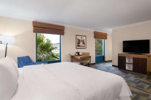 a hotel room with a bed and a flat screen tv at Hampton Inn Charleston North in Charleston