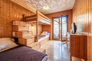 a bedroom with a bunk bed and a desk and a tv at Au soleil des coeurs - 6 pers in Morzine