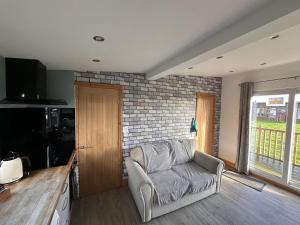 a living room with a chair and a brick wall at B3 Rickardos Holiday Lets in Mablethorpe