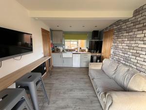 a living room with a couch and a brick wall at B3 Rickardos Holiday Lets in Mablethorpe
