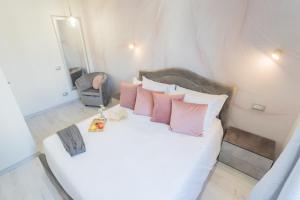 a bedroom with a white bed with pink pillows at Cernobbio Dream Suites by Rent All Como in Cernobbio