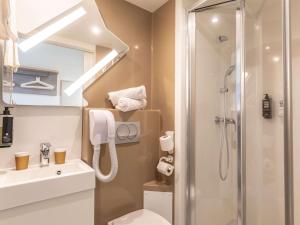 a bathroom with a shower and a toilet and a sink at ibis budget Ciboure St-Jean-Luz in Ciboure