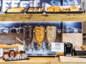 a shelf with three glass containers filled with food at IBIS BUDGET Biarritz - Anglet in Anglet