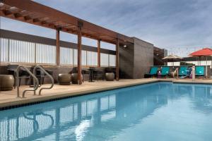 a pool at a hotel with chairs and tables at Home2 Suites By Hilton Las Cruces in Las Cruces