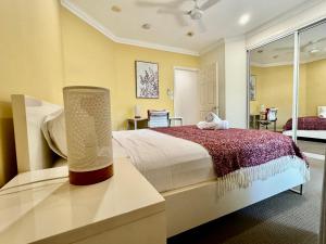 a bedroom with a large bed with a lamp on a table at Townsville Beachfron Apartments on the Strand - 2 in Townsville +41 photos