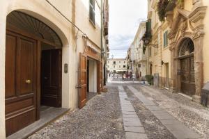 uma rua vazia num beco com edifícios em Piazza Civica em Alghero