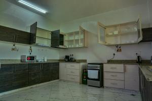 an empty kitchen with wooden cabinets and appliances at Fenns Cozy Apartment - Nyali in Mombasa