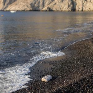 una roca sentada en una playa junto al agua en Afroditi Venus Beach Resort, en Kamari