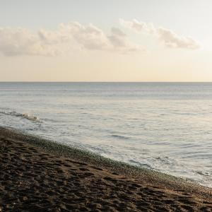 una spiaggia sabbiosa con l'oceano sullo sfondo di Afroditi Venus Beach Resort a Kamari