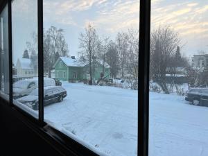 a view of a snow covered yard from a window at ”Paris” -2BR with sauna&balcony in Tornio
