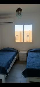 um quarto com 2 camas, um lustre e 2 janelas em sea street hadaba em Sharm el Sheikh