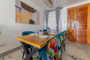 a dining room table with chairs and a wooden table at Macgregor Apartment in Nairobi