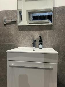 a bathroom with a white sink and a mirror at Modern Apartment in Holland Park in London