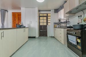 a large kitchen with a stove top oven in it at Macgregor Apartment in Nairobi