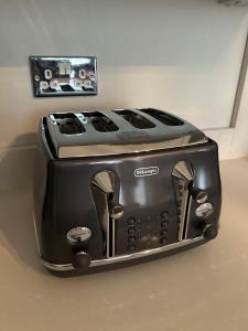 a black toaster sitting on a counter in a kitchen at Modern Apartment in Holland Park in London