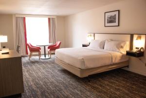 Habitación de hotel con cama, mesa y sillas en Railroad Pass Hotel and Casino Ramada by Wyndham, en Boulder City