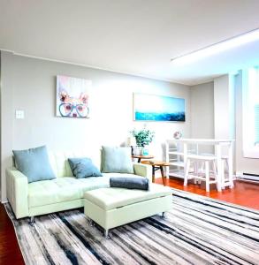 a living room with a white couch and a table at Redwood loft at Park Place King bed walk in closet fast WIFI and free coffee in Wilmington