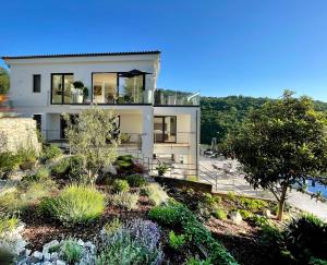 a house on a hill with a garden at Villa White Pearl Opatija Luxury Stay with Pool and Sea View in Opatija
