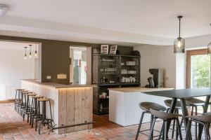 a kitchen with a counter and some chairs and tables at Charming Roger's Farm in Kortrijk