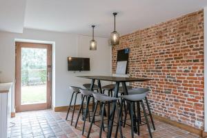 eine Küche mit einer Ziegelwand, einem Tisch und Stühlen in der Unterkunft Charming Roger's Farm in Kortrijk