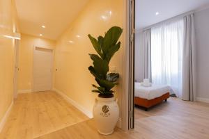 a room with a large vase with a plant in it at Relais At Via Veneto in Rome