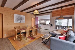 ein Wohnzimmer und eine Küche mit einem Tisch und Stühlen in der Unterkunft Chalet au bois des écureuils classé trois étoiles. in Muhlbach-sur-Munster