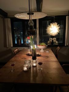 una mesa de madera con copas de vino y una lámpara. en Elins Lycka i Viken en Viken