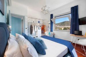 ein Schlafzimmer mit einem großen Bett mit blauen Kissen in der Unterkunft Sorrento Realty Holidays Alpa Suite in Sant'Agnello