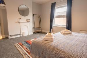 ein Schlafzimmer mit einem Bett mit Handtüchern darauf in der Unterkunft Stylish 3 bed home near central Chester - sleeps 6 in Chester