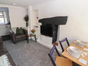 a living room with a fireplace and a dining table at Quarter Deck in Ulverston