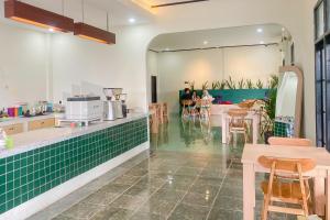 ein Restaurant mit Tischen und einem Spiegel in der Unterkunft Aman Guest House Redpartner in Palangkaraya