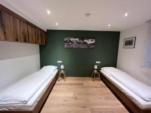 a room with two beds and a green wall at Moderne Wohnung mit Ausblick in Niedernhall