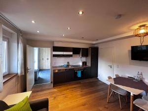 a kitchen and living room with a table and chairs at Moderne Wohnung mit Ausblick in Niedernhall