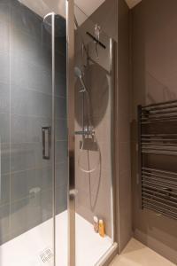La salle de bains est pourvue d'une douche avec une porte en verre. dans l'établissement DIFY Concorde - Centre Ville, à Lyon