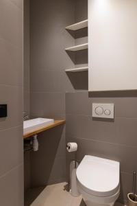 La salle de bains est pourvue de toilettes blanches et d'un lavabo. dans l'établissement DIFY Concorde - Centre Ville, à Lyon