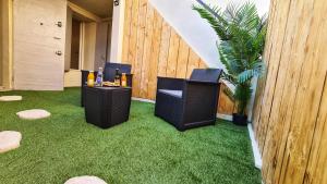 a patio with two chairs and a table on grass at CHAMBRE MIROIR Marseille T2 + jardin privé in Marseille