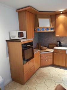 a small kitchen with wooden cabinets and a microwave at Ferienhaus-Landliebe-Wohnung-9048-2 in Dänschendorf