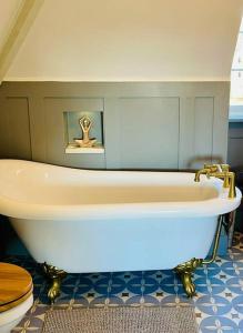 a bathroom with a bath tub and a toilet at Beautiful One Bed Apartment in West End Folkestone in Kent